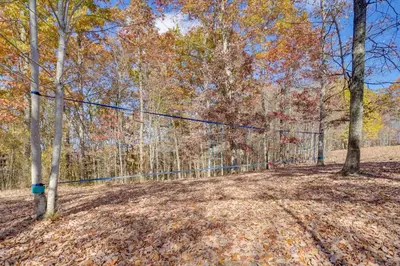 a fence in the middle of a forest at Shared Pond and Trails Rosedale Cottage! in Rosedale