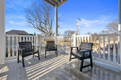 two chairs on a porch with a white fence at Luxury Boutique Downtown Private Unit in Sandusky