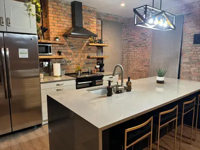 a kitchen with a stainless steel refrigerator and a sink at Jungle House Luxury Stays - Columbus Downtown Short North in Columbus