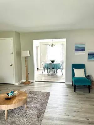 a living room with a table and a blue chair at Hot tub bubbles on Butler in Mason