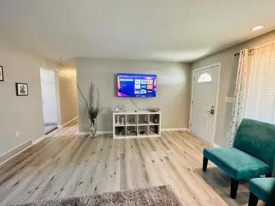 a living room with a couch and a tv on a wall at 2 Homes for large group Hot Tub in Mason