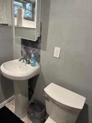 a bathroom with a white toilet and a sink at Cozy Studio Private room in Cincinnati