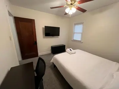 a bedroom with a bed and a flat screen tv at StayWithJay Premium Furnished Room near Cleveland Airport in Cleveland