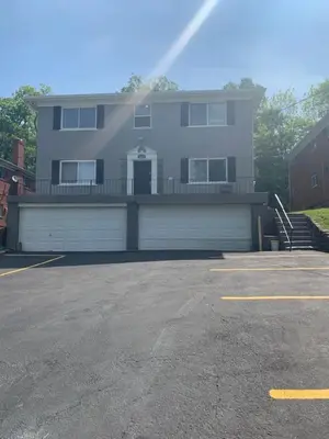 a large house with a garage in a parking lot at Filled with warmth and comfort Home away from home in Cincinnati