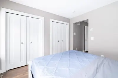 a white bedroom with a bed and two closets at Luxury Downtown Townhome Private Garage Unit 3 in Cleveland