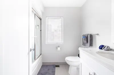 a white bathroom with a toilet and a sink at Luxury Downtown Townhome Private Garage Unit 6 in Cleveland