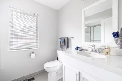 a white bathroom with a toilet and a sink at Luxury Downtown Townhome Private Garage Unit 6 in Cleveland