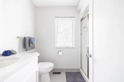 a white bathroom with a toilet and a sink at Luxury Downtown Townhome Private Garage Unit 11 in Cleveland