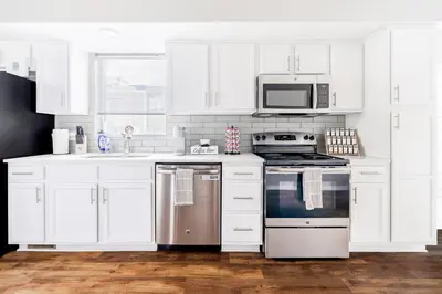 a white kitchen with a stove and a microwave at Luxury Downtown Townhome Private Garage Unit 11 in Cleveland