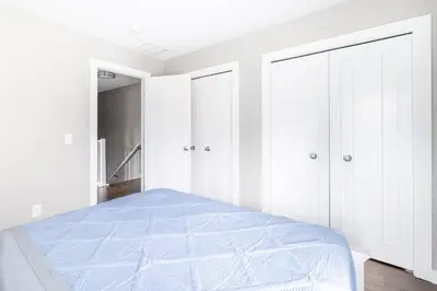 a white bedroom with a bed and white cabinets at Luxury Downtown Townhome Private Garage Unit 11 in Cleveland
