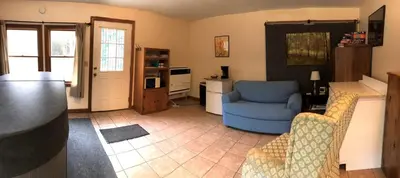 a living room with a blue chair and a kitchen at Cozy Studio Cabin Rental with Hot Tub Perfect for Glamping in Ohio in Logan