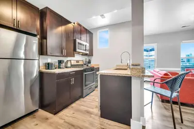 a kitchen with stainless steel appliances and wooden cabinets at Cle Suites 2BR 1BA 5 min Walk to Cle Clinic Unit 5 in Cleveland