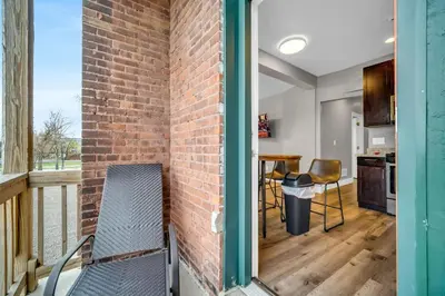 a brick wall next to a balcony with a table and chairs at Cle Suites 1BR 1BA 5 min Walk to Cle Clinic Unit 6 in Cleveland