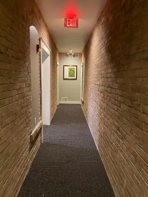 a hallway with a exit sign on a brick wall at Cle Suites 1BR 1BA 5 min Walk to Cle Clinic #7 in Cleveland