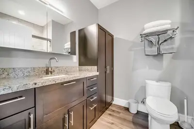 a white bathroom with a toilet and a sink at Cle Suites 1BR 1BA 5 min Walk to Cle Clinic #10 in Cleveland