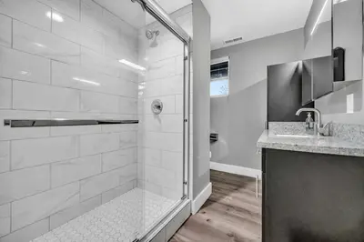 a white bathroom with a shower and a sink at Cle Suites 2BR 1BA 5 min Walk to Cle Clinic #12 in Cleveland
