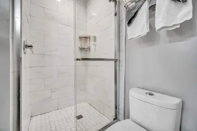 a white bathroom with a shower and a toilet at Cle Suites 2BR 1BA 5 min Walk to Cle Clinic #14 in Cleveland