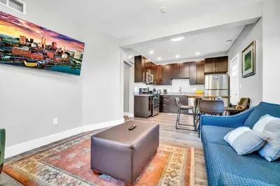 a living room with a blue couch and a kitchen at Cle Suites 1BR 1BA 5 min Walk to Cle Clinic #15 in Cleveland