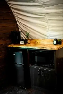 a wooden counter with a microwave on top of it at Luxury Conestoga Wagon, Perfect for a Weekend Glamping Escape from Dayton, Ohio