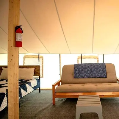 a living room with a couch in a tent at Impressive Tented Cabin with Peaceful Vistas and Fire Pit in Logan, Ohio in Logan