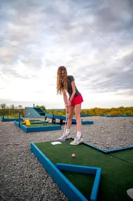 a young girl playing a game of miniature golf at Sensational Tented Cabin Nestled Amidst Trees and Fire Pit Provided in Logan, Ohio in Logan
