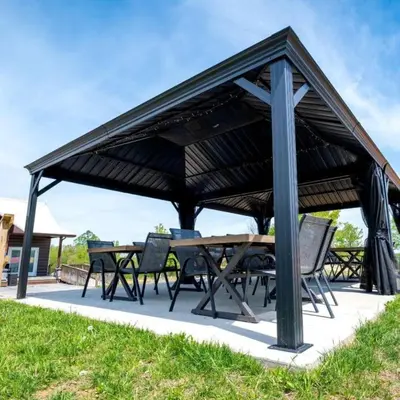 a wooden pavilion with a table and chairs at Cozy Tented Cabin with Fire Pit and Barbecue in Logan, Ohio in Logan