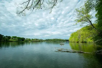 a couple of people in a boat on a river at Beautiful Tented Cabin Nestled Amidst Trees with Incredible Hiking Trails Near in Logan, Ohio in Logan