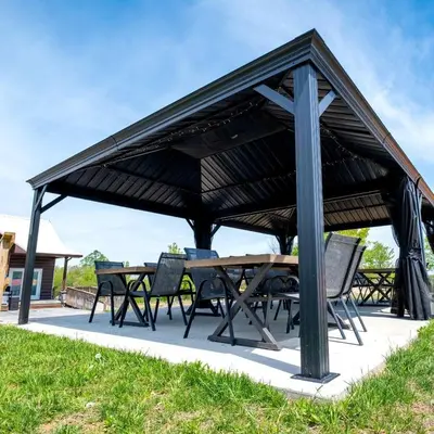 a picnic table and chairs under a black pavilion at Beautiful Tented Cabin Nestled Amidst Trees with Incredible Hiking Trails Near in Logan, Ohio in Logan