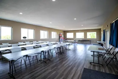 an empty room with tables and chairs in a classroom at Beautiful Tented Cabin Nestled Amidst Trees with Incredible Hiking Trails Near in Logan, Ohio in Logan
