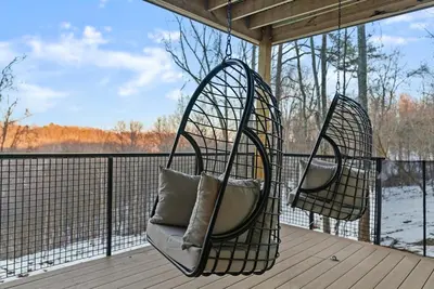 two hanging chairs on a porch with a view of the water at Adamina Canyon Luxurious, Canyon View 5BR, 3BTH 1 in Rockbridge
