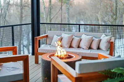 a couch sitting on a deck with a fire pit at Adamina Canyon Luxurious, Brand New 5BR 3BTH 7 in Rockbridge