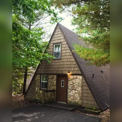 a small house with a gambrel roof and a garage at A-Frame #03 - by The Chalets in Logan