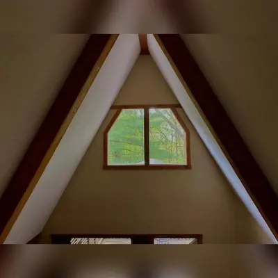 a window in the roof of a attic at A-Frame #04 - by The Chalets in Logan