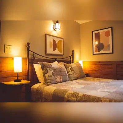 a bedroom with a bed with a lamp on it at A-Frame #04 - by The Chalets in Logan