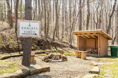 a sign for a chates fire pit in the woods at A-Frame #07 - by The Chalets in Logan