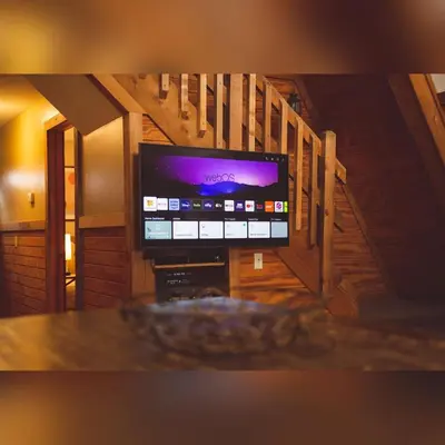 a flat screen tv in a room with a staircase at A-Frame #11 - by The Chalets in Logan