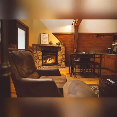 a living room with a couch and a fireplace at A-Frame #11 - by The Chalets in Logan