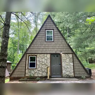 a small house with a triangular roof and a door at A-Frame #12 - by The Chalets in Logan