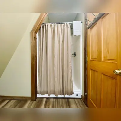 a shower door with a curtain in a room at A-Frame #14 - by The Chalets in Logan