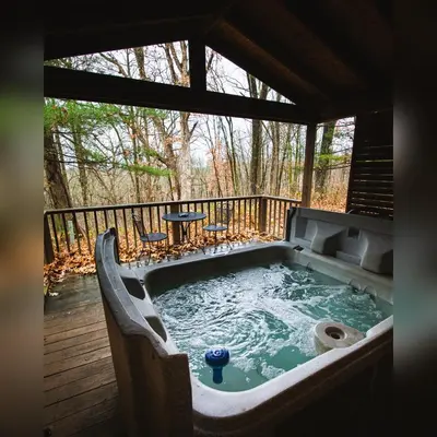 a hot tub on a deck with a table at A-Frame #15 - by The Chalets in Logan