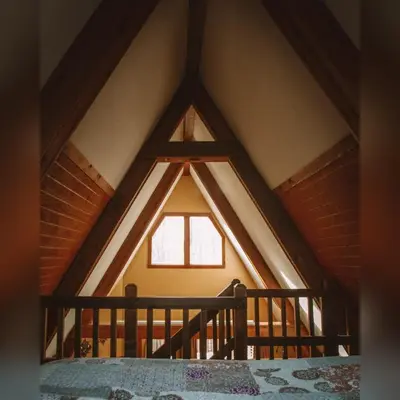 a room with a large window in a attic at A-Frame #18 - by The Chalets in Logan