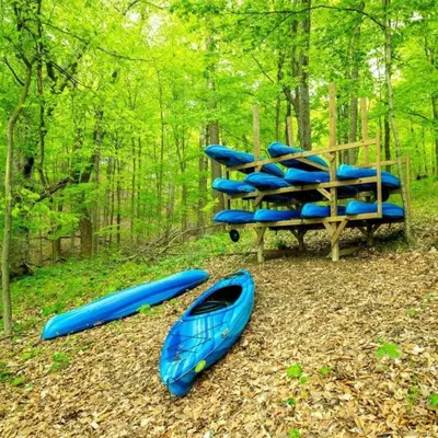 a group of kayaks sitting on the ground in the woods at Fantastic Secluded Tented Cabin with Fire Pit in Logan, Ohio in Logan