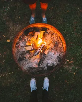 a person standing with a fire in a bowl at Alpine - by The Chalets in Logan