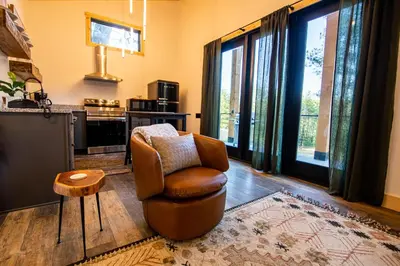 a living room with a chair and a television at Legends Lane C - by The Chalets in Logan