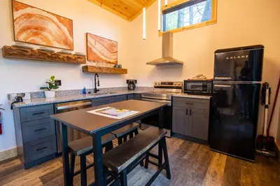 a kitchen with a black refrigerator and a table at Legends Lane C - by The Chalets in Logan