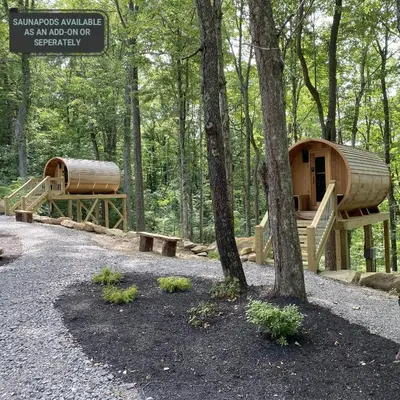 a wooden cabin in the woods with a tree at Pine Cone - by The Chalets in Logan