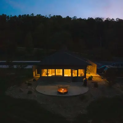 a house with a fire in front of it at night at Rockhouse - by The Chalets in Logan