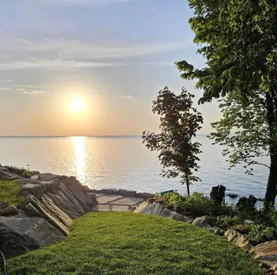 a view of the water with the sun setting over the ocean at Rustic Lakeside Vacation Rental with Beach Access in Vermilion, Ohio in Vermilion