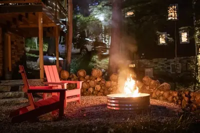a fire pit with a red chair next to a red chair at Middlefork Ridge Entire Property in Laurelville
