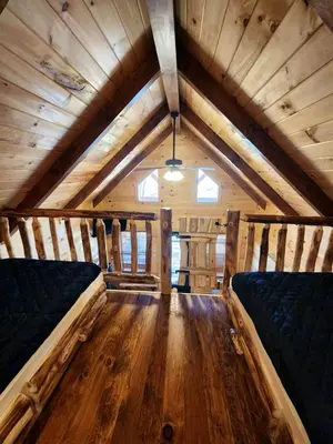 a room with two beds in a wooden house at Gorgeous Cabin Great for Family Getaways by Tappan Lake in Ohio in Deersville